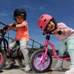 Dwójka dzieci w kaskach na rowerach dziecięcych